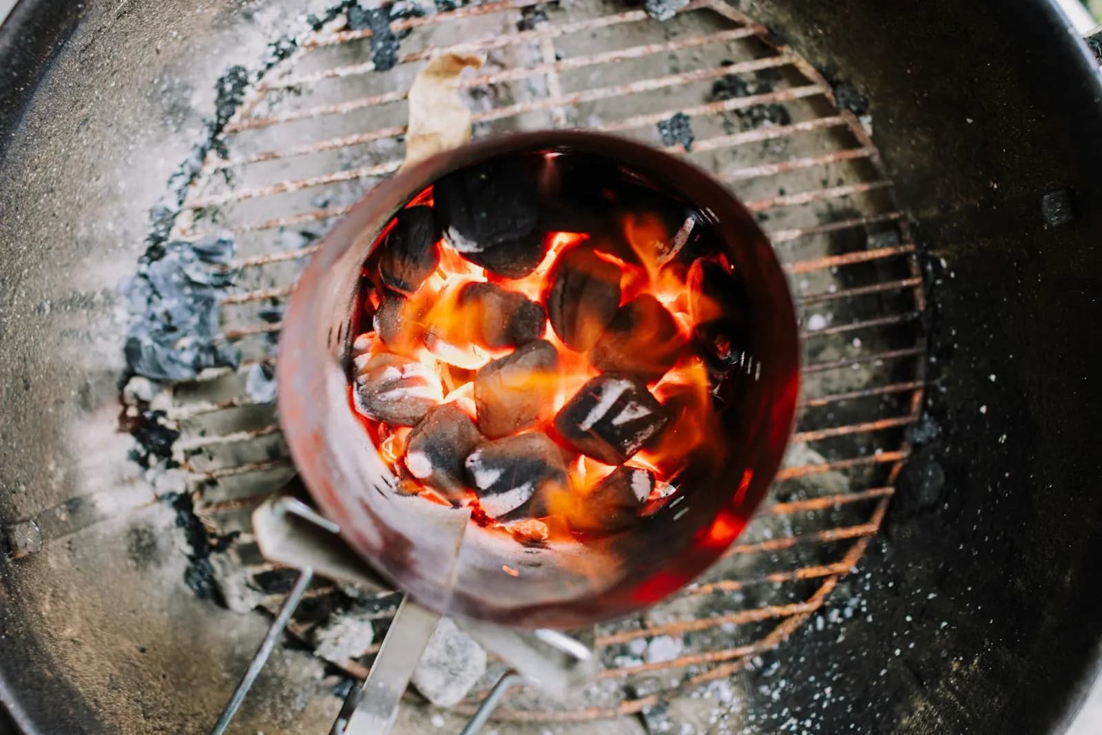 Carbón encendido dispuesto en círculo en la base de una barbacoa