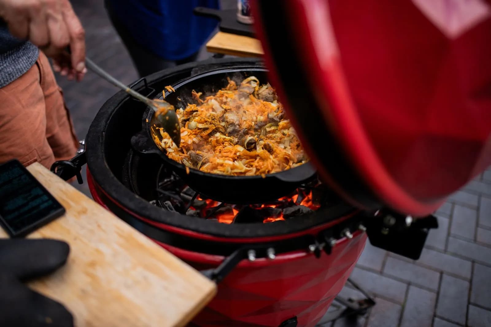Kamado cerámico abierto con comida cocinándose sobre las brasas
