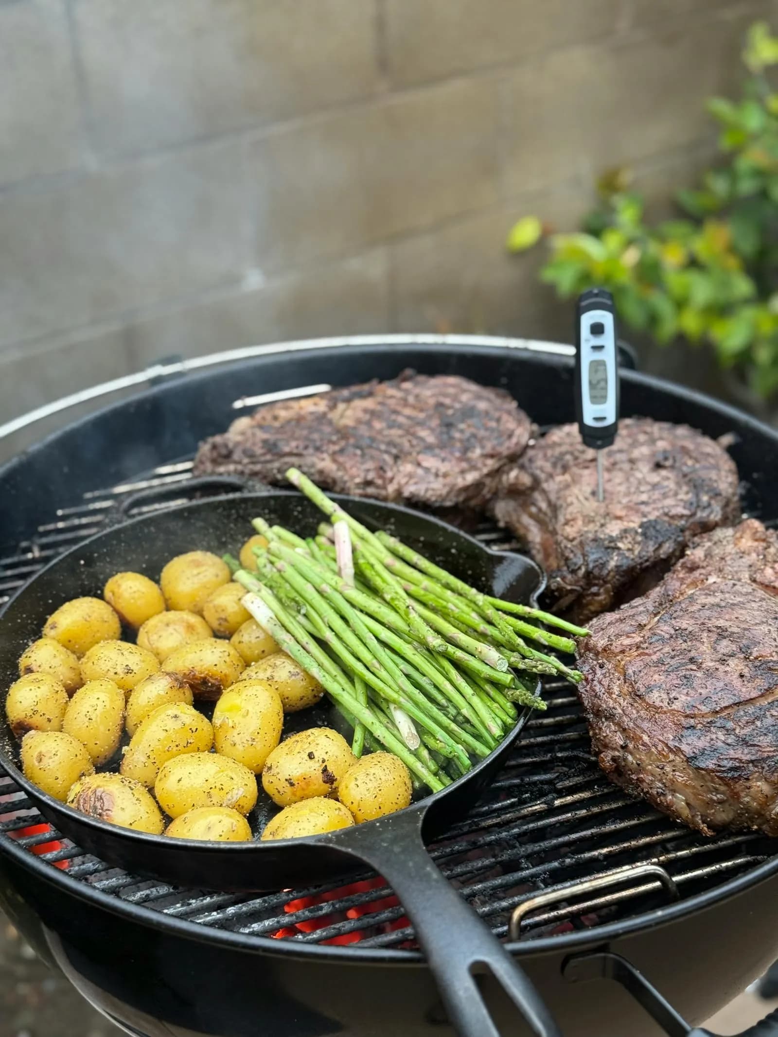 Chuletones con una sonda de temperatura clavada, junto a verduras a la parrilla