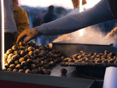 Castañas asándose sobre las brasas, removiéndose con la piel ya abierta por el calor