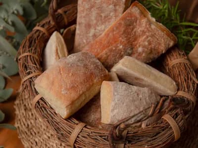 Dos chapatas de aceite de oliva recién horneadas sobre piedra, con corteza dorada crujiente y miga muy alveolada