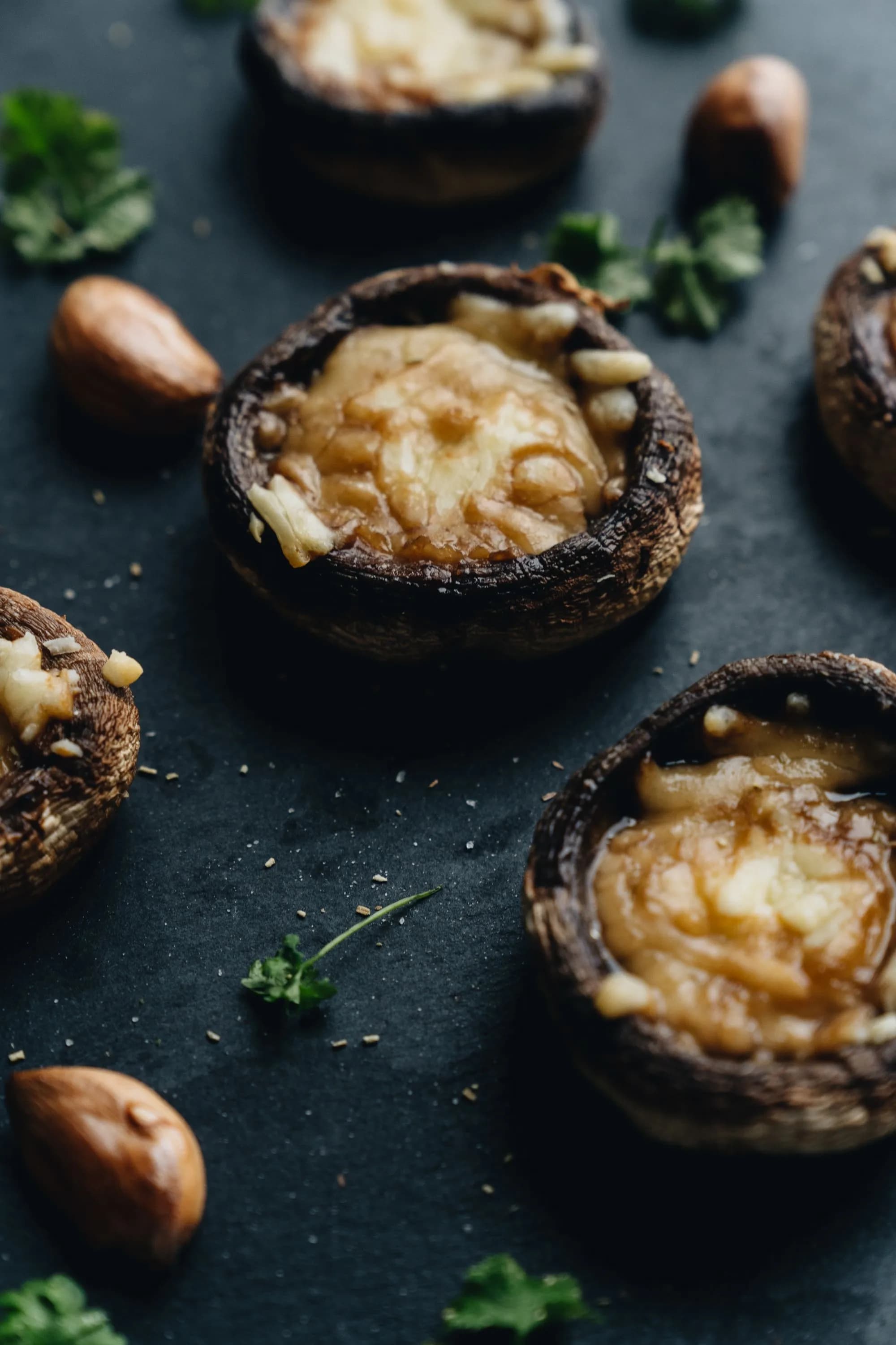 Champiñones Portobello rellenos al ajillo y gratinados con queso fundido y perejil, recién hechos.