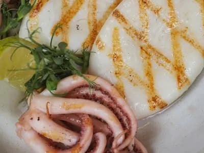 Sepia a la plancha con marcas de parrilla, limón y brotes