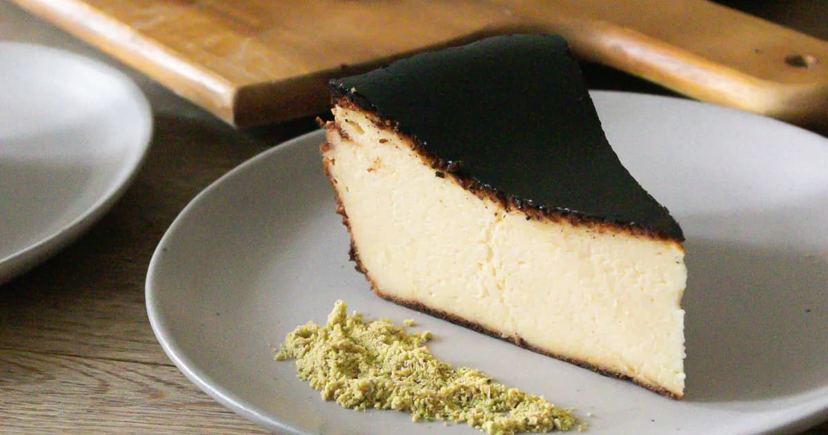 Porción de tarta de queso vasca quemada, superficie tostada y centro cremoso